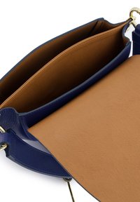 Niebieska skórzana torebka o teksturowanym wykończeniu. Posiada brązową podszewkę wewnętrzną oraz dużą centralną komorę z bezpiecznym zapięciem.