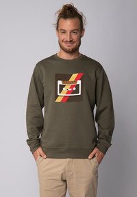 Olijfgroene sweatshirt met een retro cassettebandje grafiek in wit, bruin en rood, met een comfortabele pasvorm en geribde manchetten en onderrand.