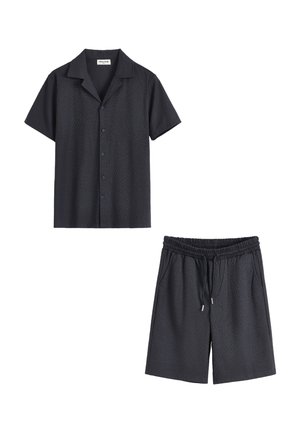 Chemise noire texturée à manches courtes boutonnée avec col, et short assorti à taille élastique avec cordon et poches latérales.