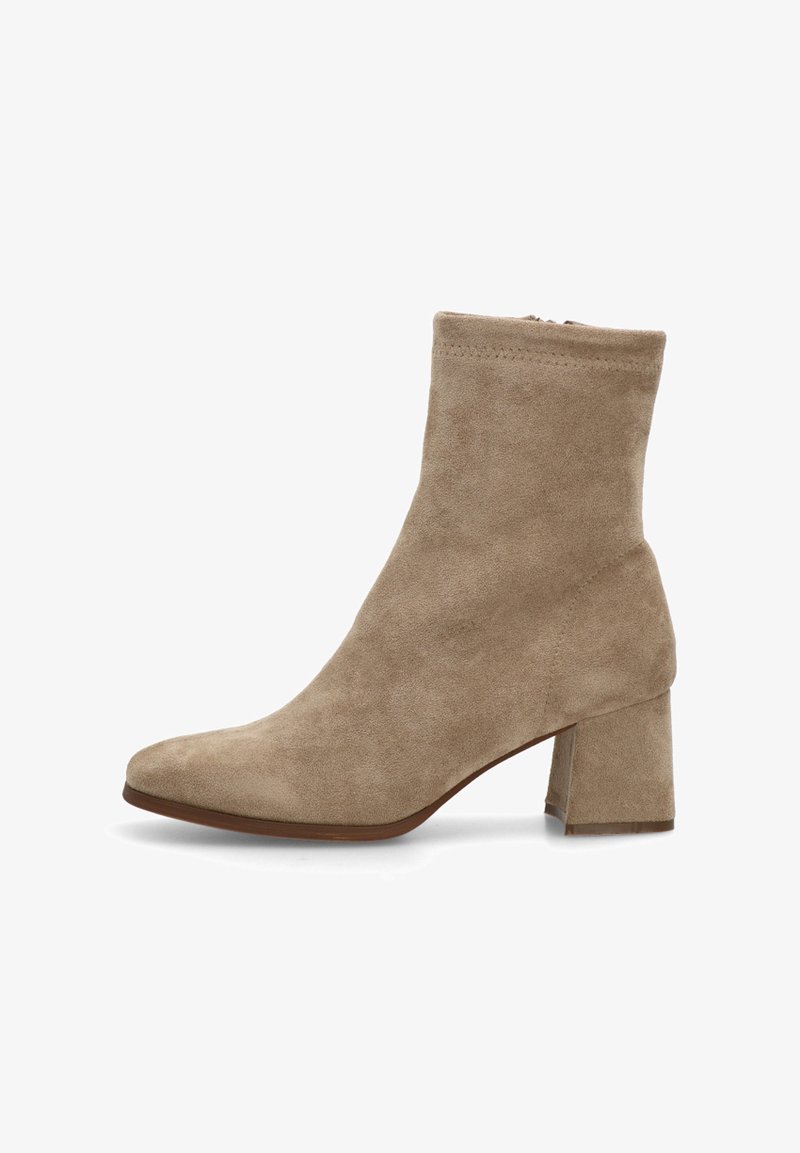 Botín de ante beige hasta el tobillo con tacón cuadrado. Presenta una punta afilada y una textura suave. Cremallera lateral para un acceso fácil. Diseño minimalista clásico.