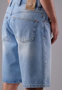 Light blue denim shorts with a relaxed fit, featuring two back pockets, visible stitching, and a tag reading "Picaldi Jeans Authentic Design."