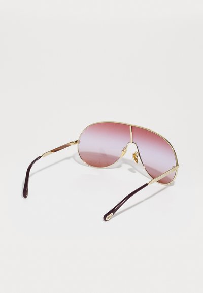 Aviator solbriller med gullfarget metallramme, gradient rosa linser og brune acetatstang med en subtil logo-detalj.