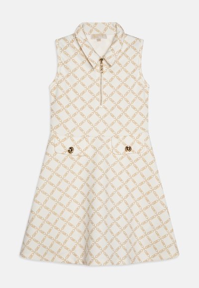 Robe sans manches en tissu ivoire avec un motif en chaîne dorée, dotée d'un col zippé, de deux poches avant avec des accents de boutons dorés.