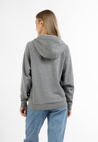Grijze hoodie met geribbelde manchetten en zoom. Zachte textuur, relaxte pasvorm en een klassiek ontwerp. Van de achterkant weergegeven, gedragen met blauwe jeans.
