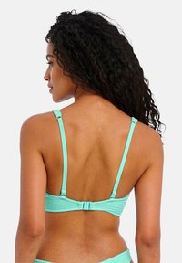 Tyrkysový bikiny top s texturovanou tkaninou, nastavitelné ramínka a zapínání na klip, pohled zezadu, zaměření na design a materiál.