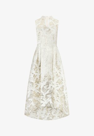 Robe blanche sans manches avec col montant, motif floral métallisé doré, taille cintrée et ourlet asymétrique.
