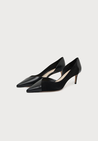 Ζευγάρι μαύρα γοβάκια kitten heel με μυτερή μύτη και συνδυασμό ματ και γυαλιστερών υφών, τοποθετημένα δίπλα-δίπλα σε λευκό φόντο.