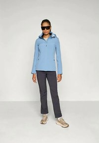 Giacca a zip blu chiaro con cappuccio, pantaloni grigi e sneakers beige. La giacca presenta un design elegante e una texture liscia.