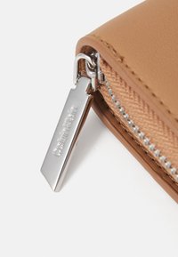 Calvin Klein MUST MEDIUM ZIP AROUND WALLET - Portafoglio - lion