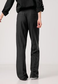 Schwarze, maßgeschneiderte Hose mit geradem Bein, ausgestattet mit zwei Gesäßtaschen und einer glatten Textur, geeignet für formelle oder legere Anlässe.