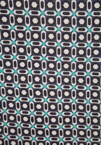 Tessuto con un motivo geometrico composto da elementi blu scuro, bianchi e turchesi. Le forme includono ottagoni e ovali disposti in una griglia.