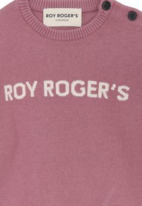 Maglione lavorato a maglia rosa con colletto a costine. Presenta la scritta bianca "ROY ROGER'S" sul petto e due bottoni neri sulla spalla.
