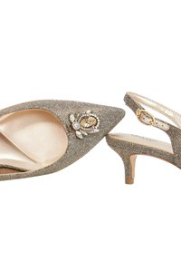 Pointed-toe slingback hakken in metallic gouden stof, met een decoratieve bloemversiering met stenen en een bescheiden hak.