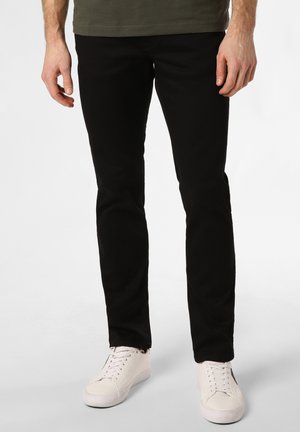 Schwarze Slim-Fit-Jeans mit glatter Textur, kombiniert mit weißen Sneakers. Die Jeans verfügen über eine Standardnaht und ein klassisches 5-Taschen-Design.