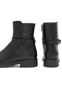 Mustadest nahast pahkluusaapad, millel on siledat töötlemist, külgniidi sulgemine ja ühtne rihma detail pahkluu ümber. Ruudukujuline plokk-konts.