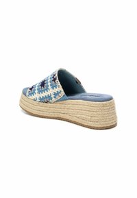 Sandalia de plataforma con parte superior trenzada en azul y blanco, suela de yute natural, diseño redondeado y plantilla blanda en azul.