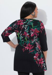 Czarna tunika z kwiatowymi wzorami w odcieniach różu, bieli i zieleni, z rękawami trzy czwarte i luźnym krojem, pokazana od tyłu.