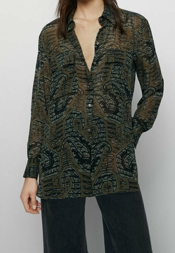 Sheer olive green button-up shirt featuring a black abstract pattern, long sleeves, and a relaxed fit. Notable collar and slightly open neckline.
