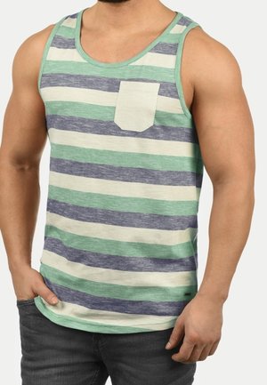 Mann trägt ein ärmelloses Tanktop mit horizontalen grünen, grauen und cremefarbenen Streifen und einer kleinen Brusttasche.