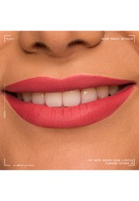 Gros plan d'une bouche souriante avec un rouge à lèvres rose mat lisse sur des lèvres bien hydratées montrant des dents propres et blanches ainsi que la texture naturelle de la peau.