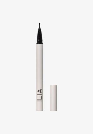 Stylo eyeliner liquide avec une pointe fine noire, corps cylindrique blanc étiqueté "ILIA" et capuchon blanc assorti à côté, sur fond blanc.