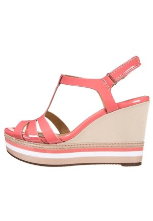 Koralfarvet kilhæl sandal i laklæder med T-rem design, beige platform og hvide og koralfarvede accentstriber. Justerbar ankelrem for pasform.