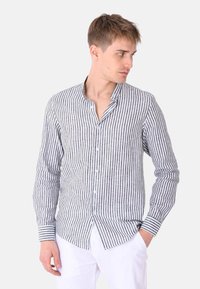 Camicia a righe grigio e bianco in lino, con colletto alla cinese, maniche lunghe e polsini a righe a contrasto.