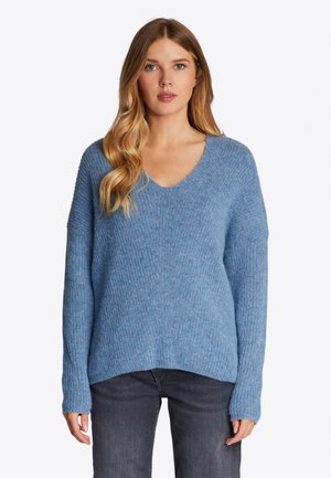Blauw gebreid sweater met een V-hals, ribbelstructuur, lange mouwen en een licht gebogen zoom. Gecombineerd met donkergrijze jeans.