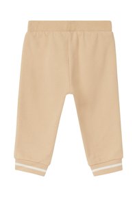 Beige katoenen sweatpants met een relaxed fit, een elastische tailleband en cuffed enkels, voorzien van witte stripaccenten bij de boorden.