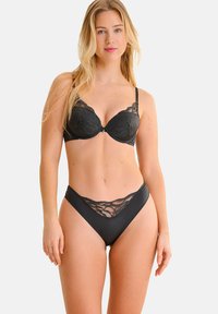 Zwart lingerie set met een balconette beha met kantdetails en bijpassende hoge taille shorts, gladde stof en verstelbare bandjes.