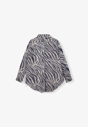 Skjorte med knapper og lange ærmer med sort-hvidt zebra stribet mønster og en brystlomme foran på hvid baggrund.