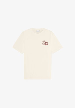 Creme t-shirt lavet af bomuld, med rund halsudskæring, korte ærmer og et maroon "LD" logo på venstre bryst.