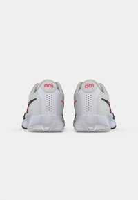 Lys grå sportssko med sorte detaljer og et pink logo. Mesh-overdel med perforeringer og en tekstureret sål. Nummer "001" på hælen.