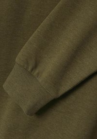 Indumento verde oliva a maniche lunghe con polsini a coste e texture morbida, caratterizzato da una finitura in tessuto liscia e cuciture minimali.
