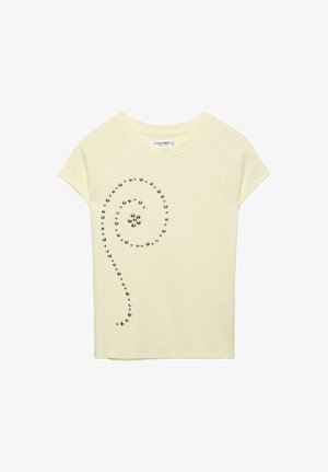 Haut court jaune à manches courtes avec encolure ronde, présentant une spirale décorative de clous métalliques sur le côté gauche avant.