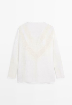 Witte, pluizige trui met lange mouwen en een subtiel V-vormig patroon op de rug, plat weergegeven tegen een witte achtergrond.