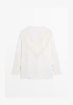 Maglione bianco a maniche lunghe e soffice con un delicato motivo a V sulla schiena, mostrato disteso su sfondo bianco.