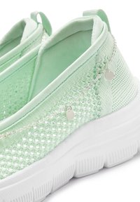 Hellgrüne Slip-On-Sneaker mit einem Obermaterial aus Mesh, weißer Gummisohle, strukturiertem Muster und minimalistischen silbernen Kettenakzenten.