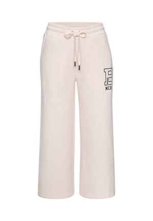 Hand in der Tasche einer hellrosa Jogginghose mit elastischem Bund und schwarzem "Bench B MCR'89"-Logo auf dem Oberschenkel gedruckt.