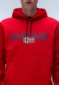 Felpa rossa con cappuccio, caratterizzata da un design grafico con "Napapijri" e una bandiera norvegese. Include una tasca frontale e lacci regolabili.