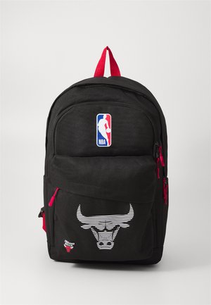 Black backpack with red accents, featuring a Chicago Bulls logo, NBA patch, zippered pockets, and a smooth textured surface.