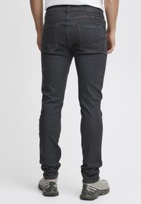 Mörka denimjeans med slim fit, med bakfickor med vinklade sömmar och en ren finish. Matcher med grå sportskor.
