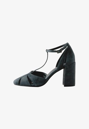 Dark blue suede high-heeled shoe with an open toe, crisscross straps, and a block heel. Features cutout details along the sides.