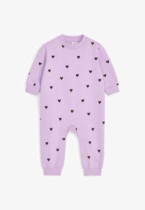 Combinaison bébé lilas à manches longues avec motifs de cœurs noirs, avec boutons-pression à l'épaule et le long des jambes intérieures pour faciliter l'habillage.