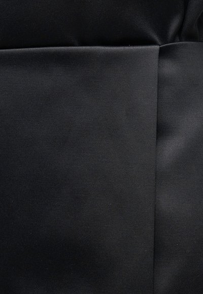 Nærbilde av svart stoff med en jevn tekstur og en vertikal søm som går ned langs høyre side.