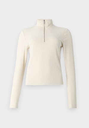 Cream ribbed pullover with long sleeves and a mock neck. Features a quarter zipper at the front and a fitted design. Plain texture.