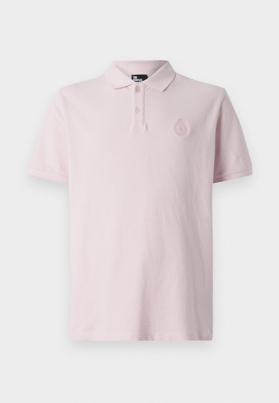 Polo krekls gaiši rozā audumā ar klasisku apkakli, trīs pogu aizdari un izšūtu logo uz krūtīm. Mīksta tekstūra, īsas piedurknes.
