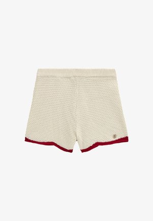 Strick-Shorts in Creme mit einem strukturierten Muster, dazu einem roten Saumdetail und einem kleinen Logo-Akzent an der Seite.