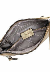 Interno di portafoglio metallico dorato con un vano con zip, rivestimento in tessuto a motivo e uno slot per schede con etichetta testurizzata.