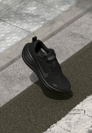 Adidași negri Nike pentru alergare, cu tissu texturat, formă rotunjită, design cu șireturi și un logo cu sistem de amortizare Zoom Air pe lateral.